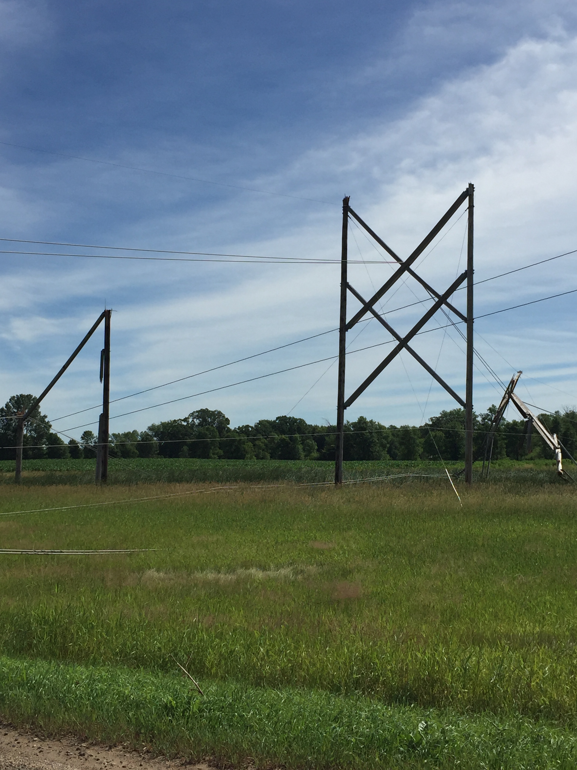 Broken power line poles in a field. 